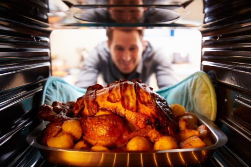 man taking turkey out of oven, worst things about being an empty nester