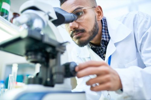 Scientist in the lab using a microscope