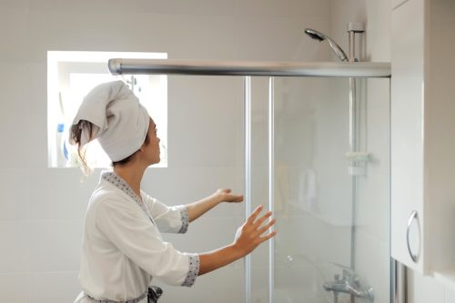 Young Woman in Bath Robe Getting Ready to Shower in the Bathroom at Home