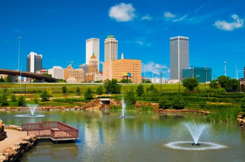 Tulsa skyline with a park, pond, and fountains in the foreground.