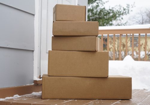 stacking delivered package boxes in front of the front door of house