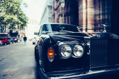 Front view of Exclusive Luxury Rolls-Royce car limousine parked in city.