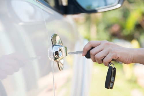 A close up of a hand unlocking a car door