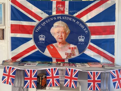 Platinum jubilee display of union jack flag with queen Elizabeth and crown on it to celebrate 70 years on throne and bunting.