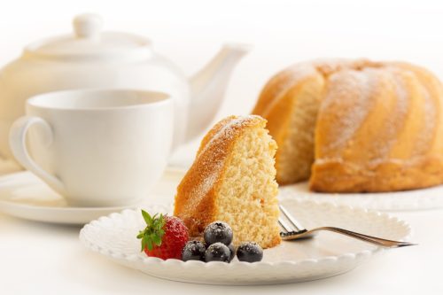 Slice of sponge cake and white porcelain.