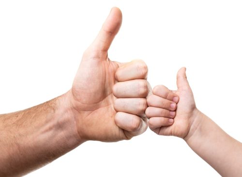 Hands of adult man and kid. Father's and child's thumbs up