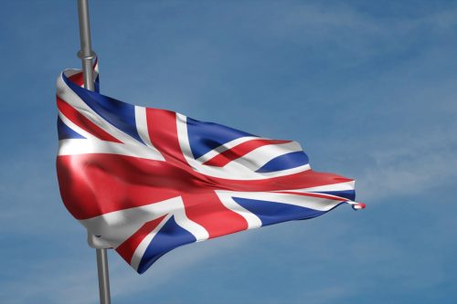 British flag waving in the wind on blue sky background