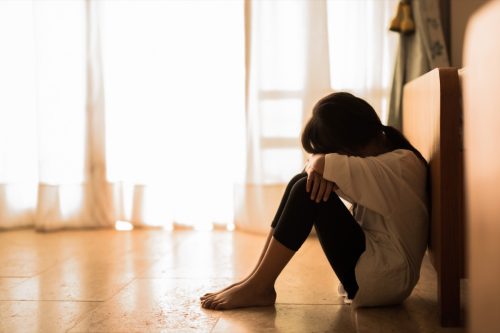 Woman seat on the floor and crying.