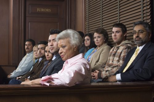 Multi ethnic jurors in witness stand of courthouse.