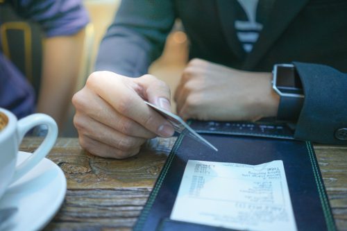 A businessman is paying his bill by using credit card.