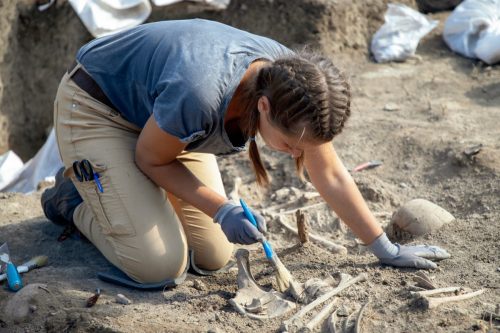 Woman archaeologist working on human remains excavation