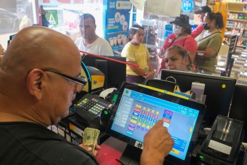 People wait in line in Blue Bird Liquor store to purchase Mega Millions lottery tickets in Hawthorne, Calif., 