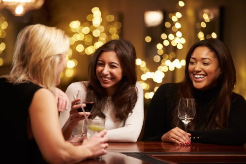 Group Of Female Friends Enjoying Evening Drinks In Bar