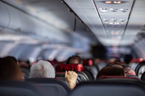 man holding airplane seat turbulence