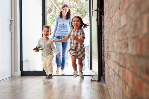 Excited Children Arriving Home With Parents