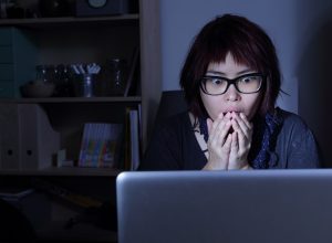 woman looks at laptop in shock