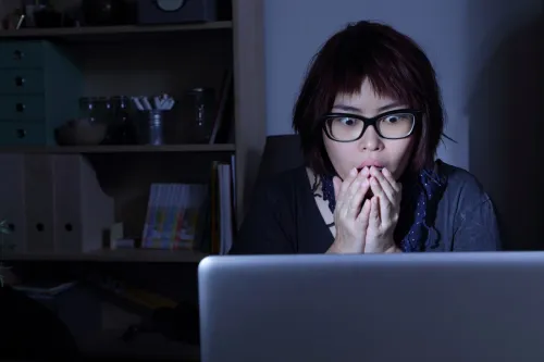 woman looks at laptop in shock