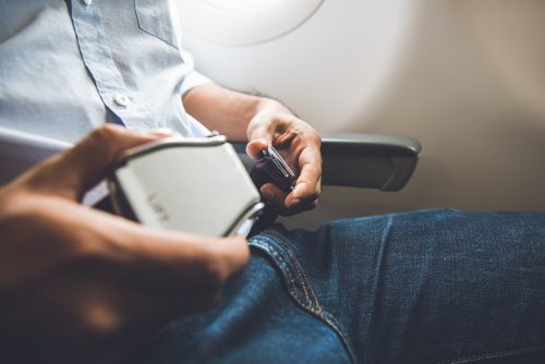 A man buckling his seatbelt on a plane