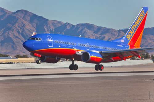 southwest airplane taking off with mountains in the background