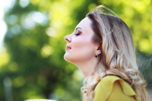 Woman with blond hair in summer park