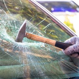 Technician use hammer for Broken car windshield. Selective focus.