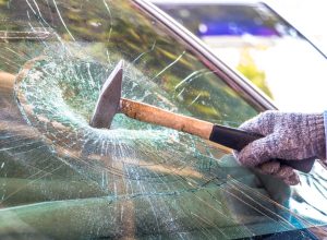 Technician use hammer for Broken car windshield. Selective focus.