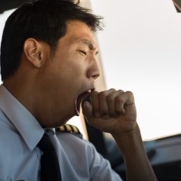 Tired man yawning at work.