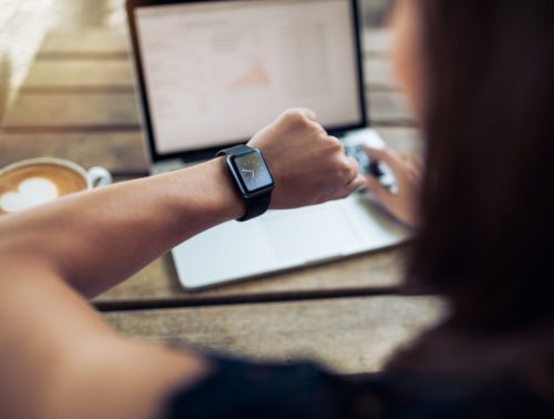 Close up shot of a woman checking time on her smartwatch.