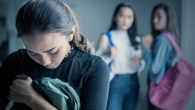 Teenage girl bullied by her colleagues in the classroom.