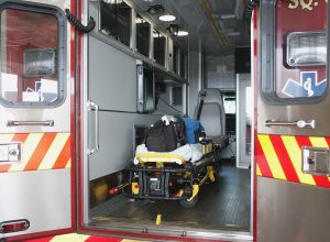Paramedic's truck with open back doors, where stretcher and medical equipment is visible.