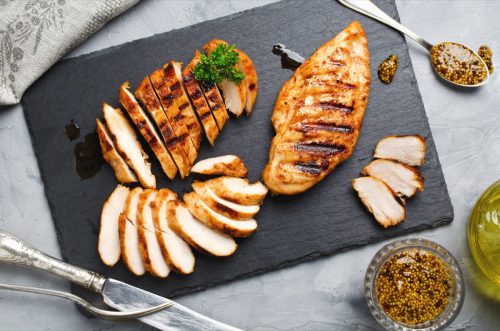 Grilled chicken fillets on slate plate