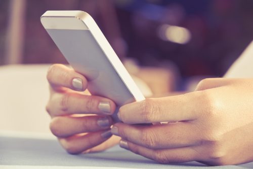 Woman on her phone sending a message.