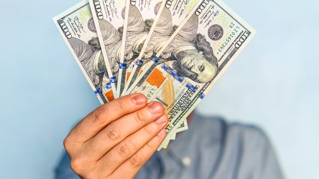 Dollars,In,The,Hands.,Businessman,In,Blue,Shirt,Holding,A