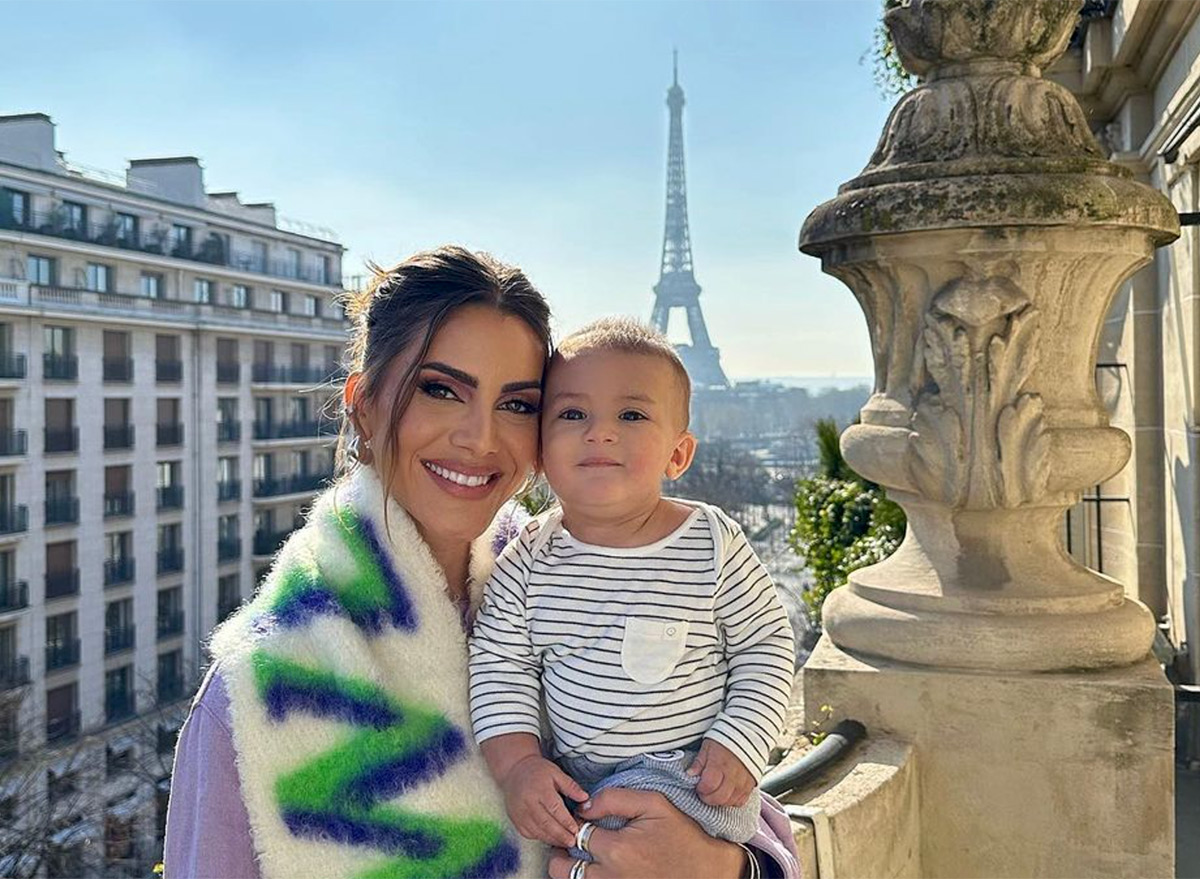Influencer Poses with Son on Edge of Balcony