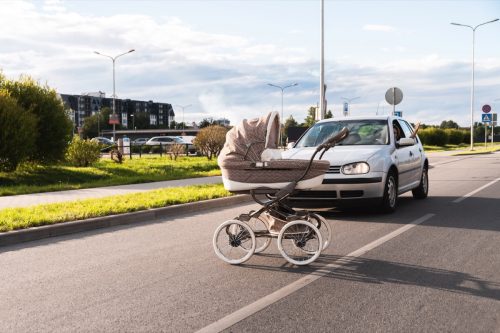 Outraged driver and baby pram rolled out in the middle of the road. Concepts of safety, traffic code and insurance.