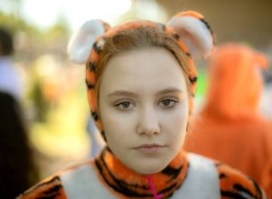 A girl dressed as a tiger. Children's animotr in a soft costume of a wild cat.