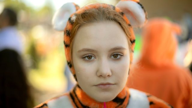 A girl dressed as a tiger. Children's animotr in a soft costume of a wild cat.