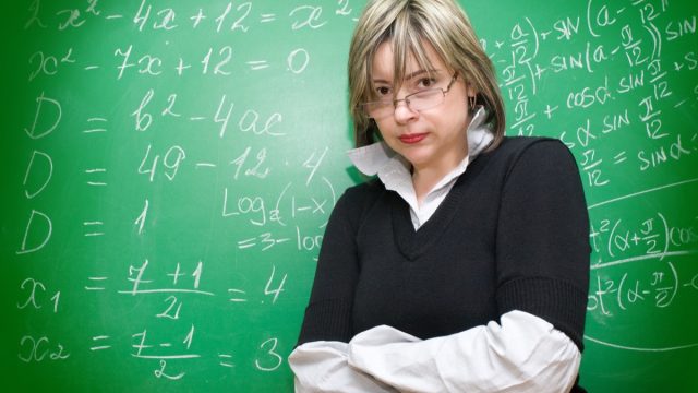 Angry,Teacher,With,Blackboard,On,The,Background