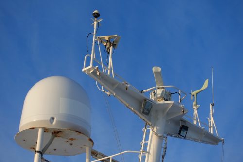 Photo of small ship's navigational system as seen in deep blue sky.