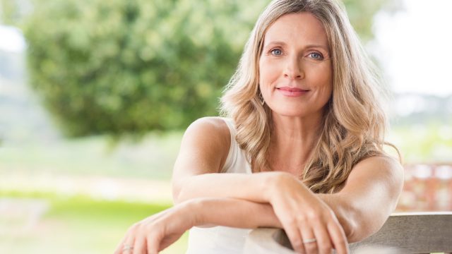 Happy,Senior,Woman,Relaxing,On,Bench,In,The,Lawn.,Close