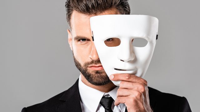 Serious,Handsome,Businessman,In,Black,Suit,Taking,Off,White,Mask