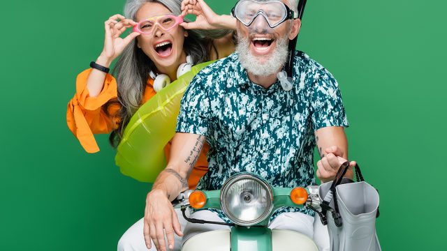 Middle,Aged,Couple,In,Goggles,Riding,Moped
