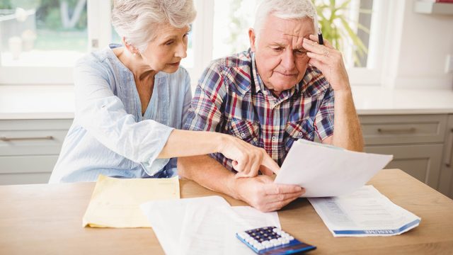Retirement,Worried,Senior,Couple,Checking,Their,Bills,At,Home