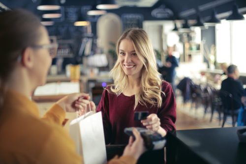 Blonde woman paying in a restaurant