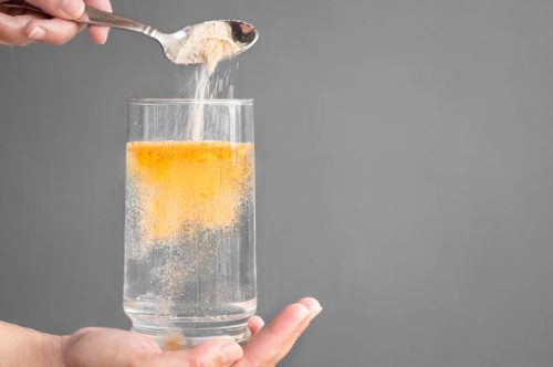 Orange fizzy powder and water glass.