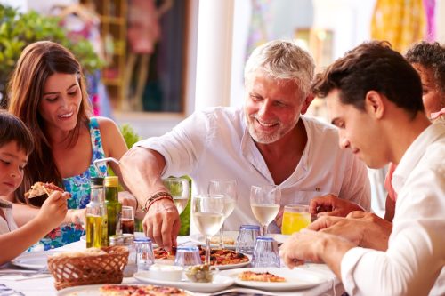 Multi Generation Family Eating Meal At Outdoor Restaurant