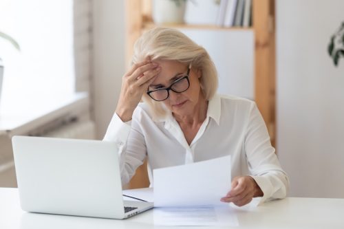 Mature businesswoman reading document at work.