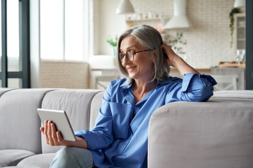 Middle aged woman holding digital tablet.