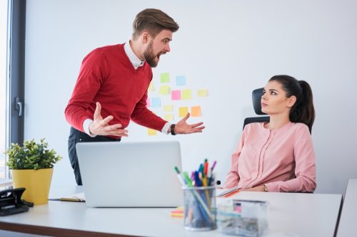 Businessman yelling at female coworker at office