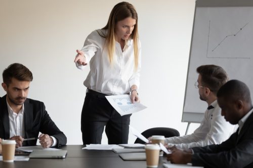 At group meeting businesspeople gathered in boardroom witnessed a conflict between female boss and employee